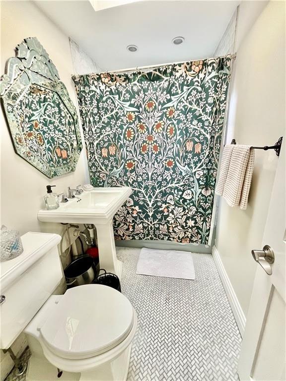 full bath featuring a shower with shower curtain, baseboards, toilet, and tile patterned floors