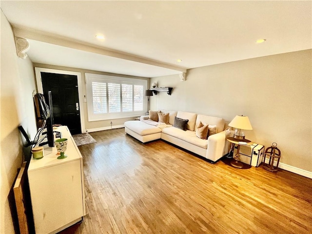 living room featuring beam ceiling, recessed lighting, baseboards, and wood finished floors