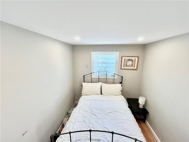 bedroom featuring baseboards and wood finished floors