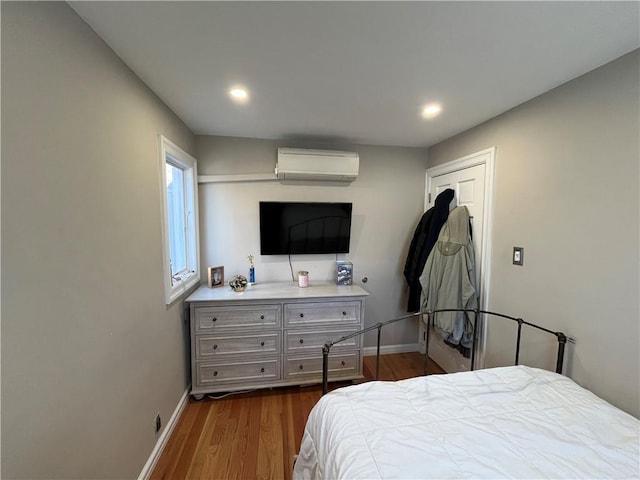 bedroom featuring dark wood-style flooring, baseboards, a wall mounted AC, and recessed lighting