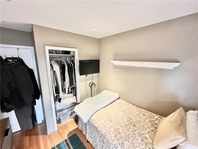 bedroom with a closet, recessed lighting, and wood finished floors