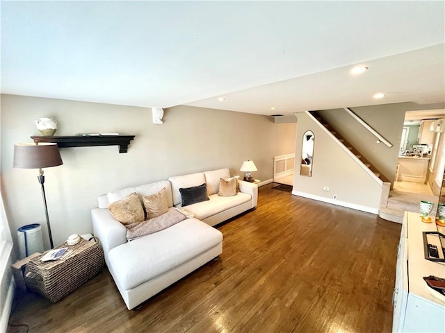living room with recessed lighting, baseboards, wood finished floors, and stairway