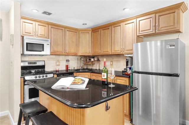 kitchen featuring a sink, stainless steel appliances, visible vents, and decorative backsplash