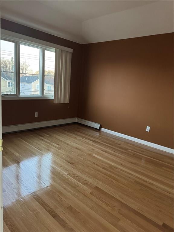 empty room with baseboards and light wood-style floors