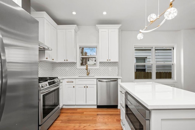 kitchen with a sink, white cabinetry, appliances with stainless steel finishes, and light countertops