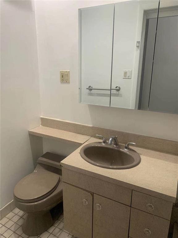 bathroom featuring tile patterned flooring, toilet, and vanity