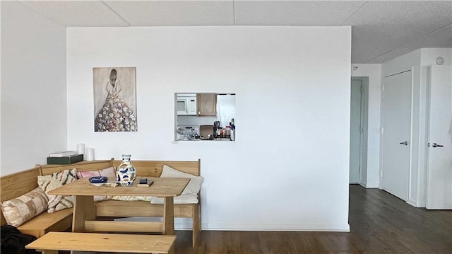 dining room featuring wood finished floors, baseboards, and breakfast area