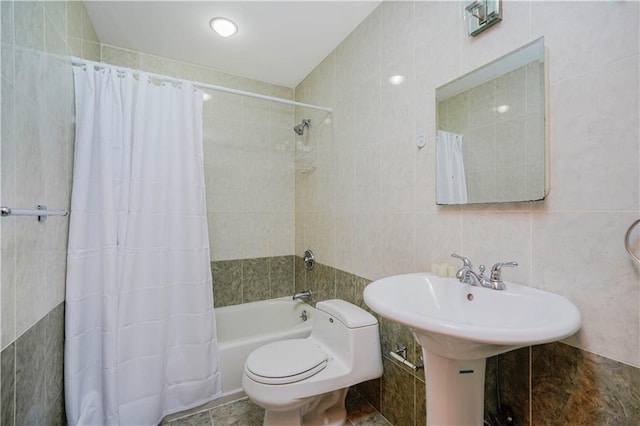 bathroom with tile walls, toilet, and shower / bath combo