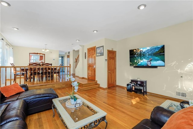 living area with baseboards, visible vents, light wood-style flooring, recessed lighting, and a chandelier