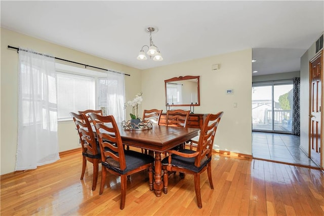 dining space featuring visible vents, baseboards, light wood-type flooring, and a chandelier