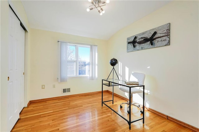 home office featuring visible vents, light wood-type flooring, baseboards, and vaulted ceiling