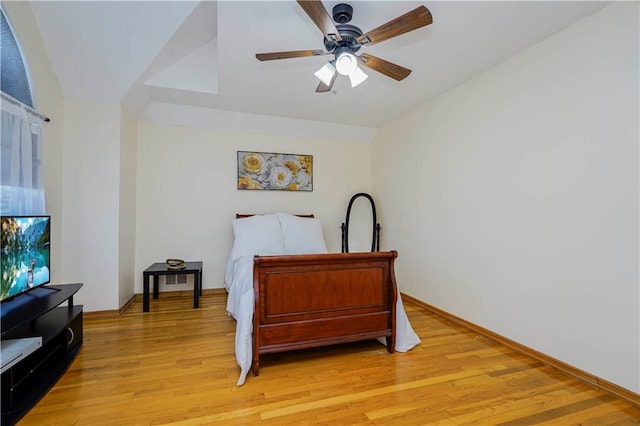 bedroom with light wood finished floors, baseboards, and a ceiling fan