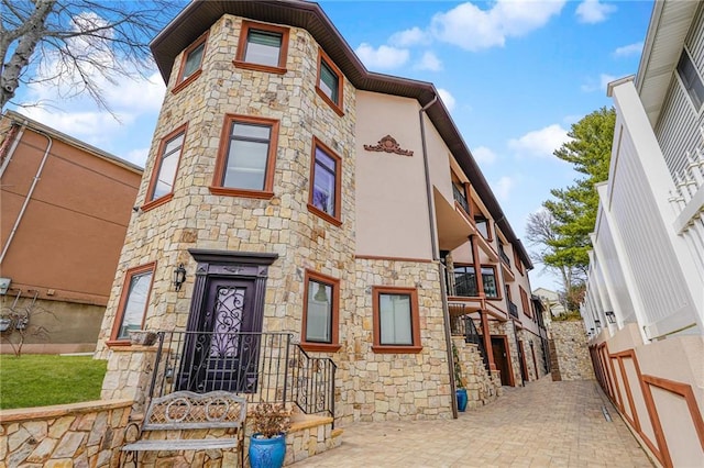 view of front facade with stone siding and stucco siding