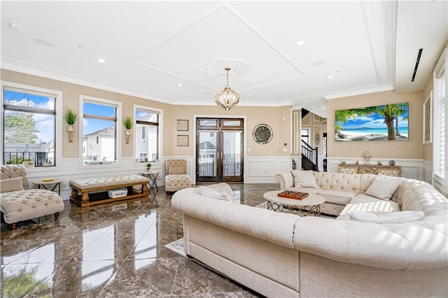 living room with crown molding, a decorative wall, marble finish floor, and wainscoting