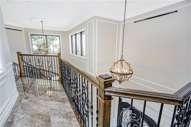 corridor featuring an upstairs landing, crown molding, and an inviting chandelier