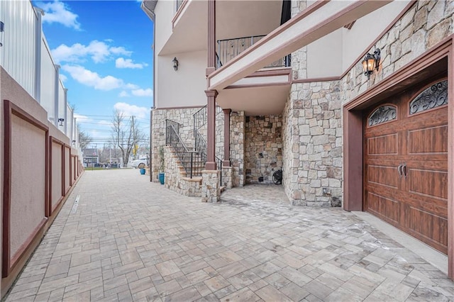 exterior space featuring stone siding and stucco siding