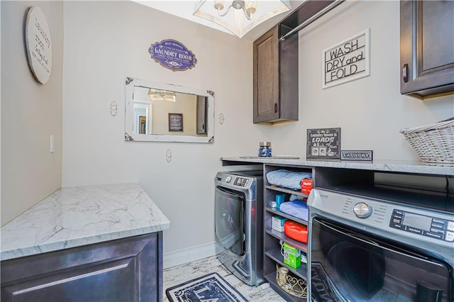 clothes washing area with separate washer and dryer and cabinet space