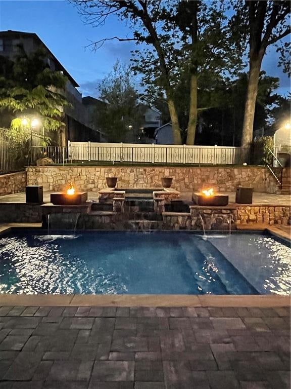 view of pool featuring a patio, fence, a fenced in pool, and an outdoor fire pit