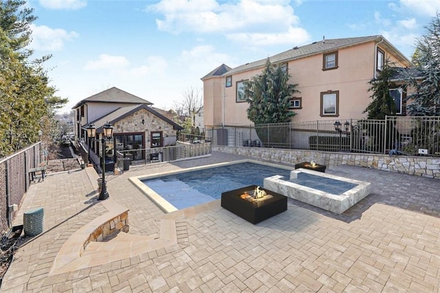 view of pool featuring fence, a fire pit, and a patio area