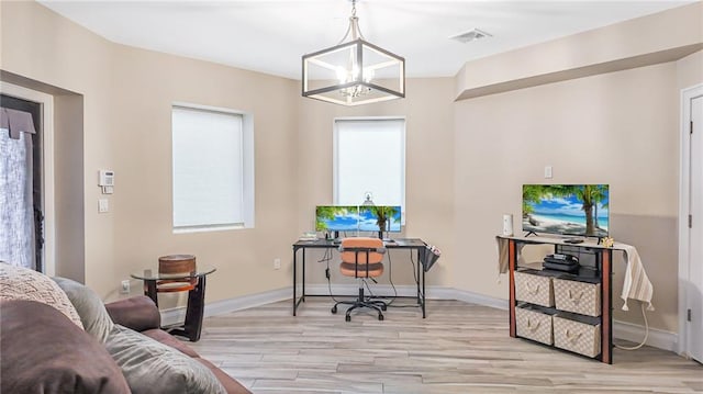 office space with a notable chandelier, light wood-style floors, visible vents, and baseboards