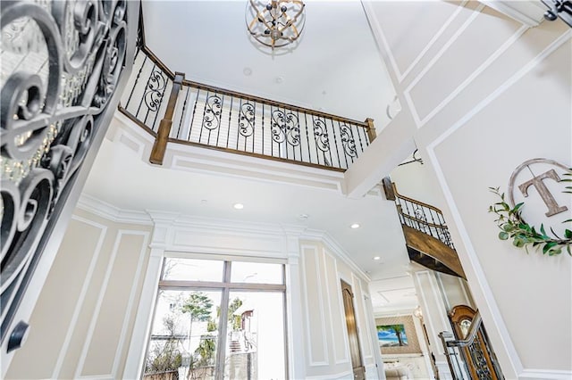 interior space featuring stairs, a high ceiling, recessed lighting, and ornamental molding