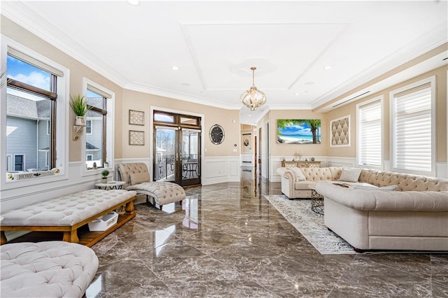 living area with an inviting chandelier, wainscoting, crown molding, a decorative wall, and marble finish floor