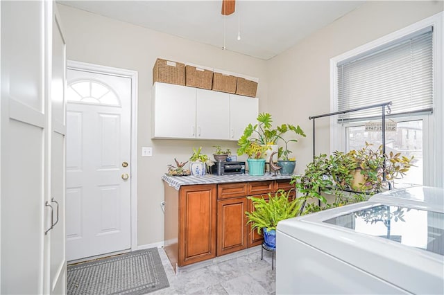 kitchen featuring light countertops, plenty of natural light, brown cabinets, and marble finish floor