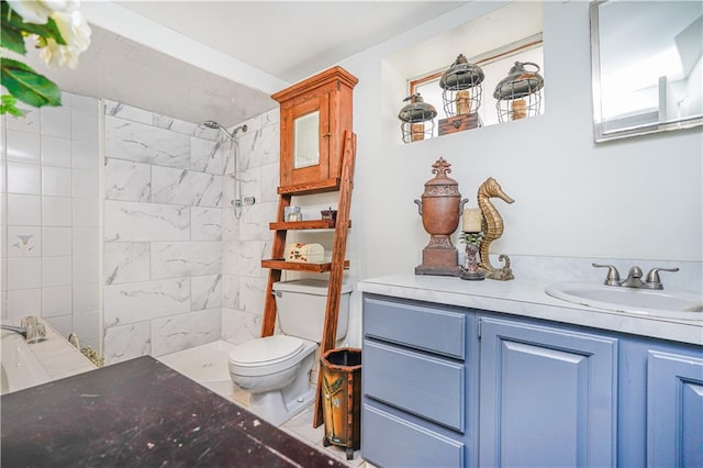 bathroom with vanity, toilet, and a tile shower