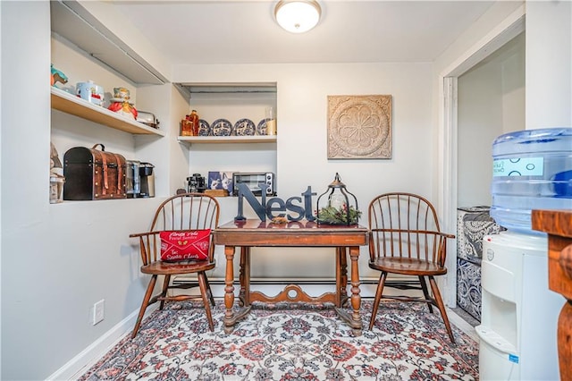 office space featuring a baseboard heating unit and baseboards