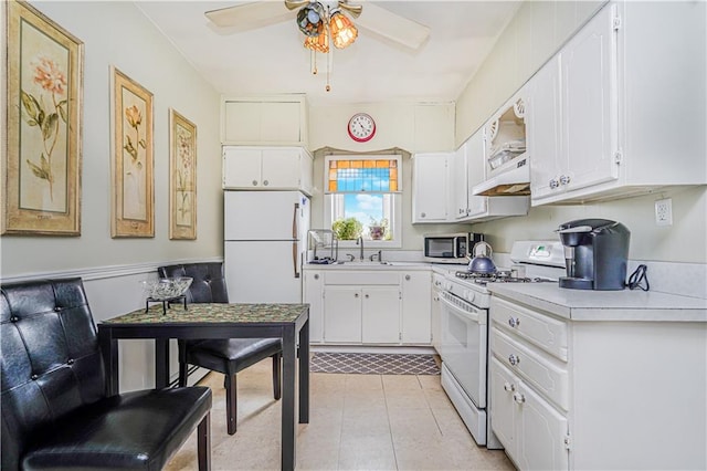 kitchen featuring light tile patterned floors, white appliances, white cabinetry, and a sink