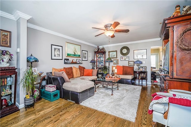 living area featuring ornamental molding, baseboards, a ceiling fan, and wood finished floors