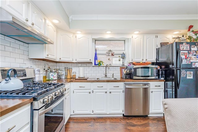 kitchen with ornamental molding, a sink, under cabinet range hood, dark wood-style floors, and stainless steel appliances