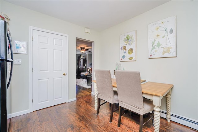 dining room with dark wood finished floors, baseboards, and baseboard heating