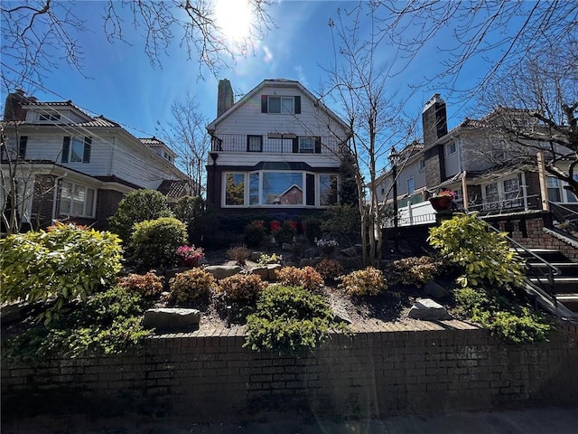 view of front of property featuring a balcony and a chimney