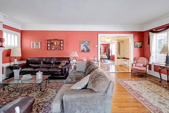 living room featuring radiator, plenty of natural light, wood finished floors, and ornamental molding