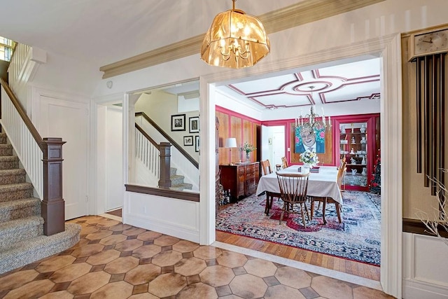 dining room featuring a notable chandelier, stairway, and ornamental molding