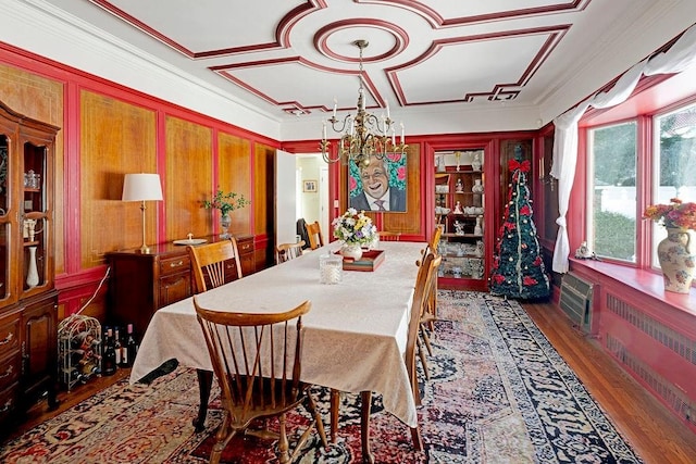 dining area featuring a notable chandelier, wood finished floors, crown molding, and radiator heating unit