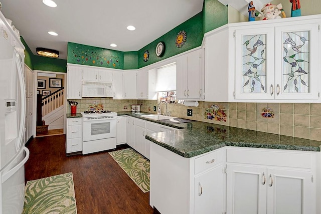 kitchen featuring white appliances, white cabinets, and a sink