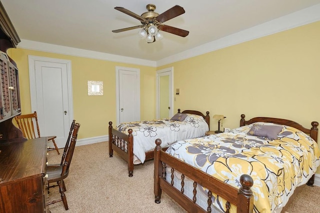 bedroom with a ceiling fan, light colored carpet, and baseboards