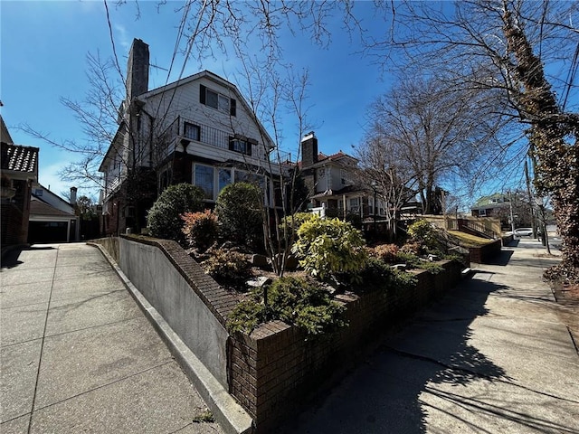 view of side of property with a gambrel roof and a chimney