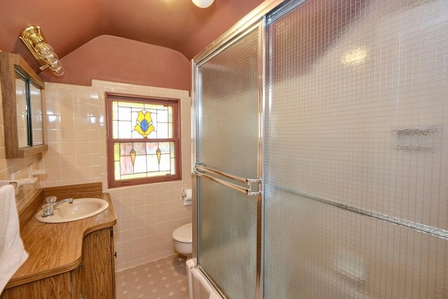 bathroom featuring tile patterned floors, a shower with shower door, toilet, tile walls, and vaulted ceiling