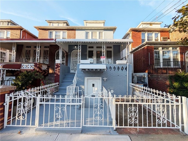 view of front of home featuring stairs, a porch, brick siding, and a fenced front yard