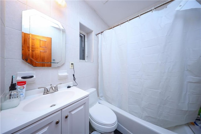 full bathroom featuring toilet, tile walls, vanity, and shower / bath combo