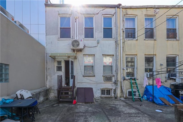 rear view of house featuring stucco siding, central AC unit, entry steps, and ac unit