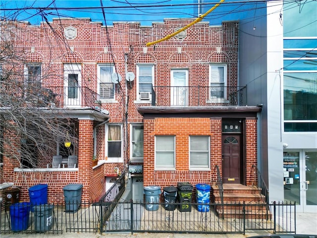 townhome / multi-family property featuring brick siding and a fenced front yard