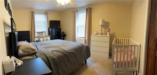 carpeted bedroom featuring cooling unit and a ceiling fan