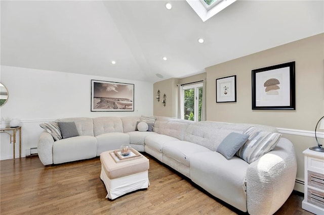 living area featuring lofted ceiling with skylight, recessed lighting, wood finished floors, and baseboard heating