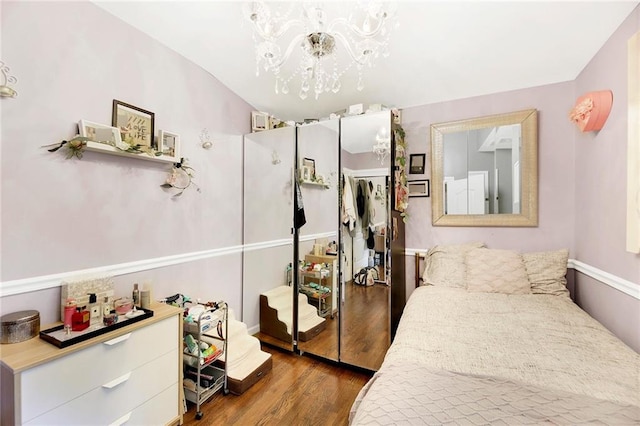 bedroom featuring a notable chandelier and wood finished floors