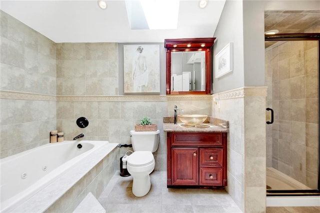 bathroom with tile walls, a stall shower, a tub with jets, vanity, and toilet