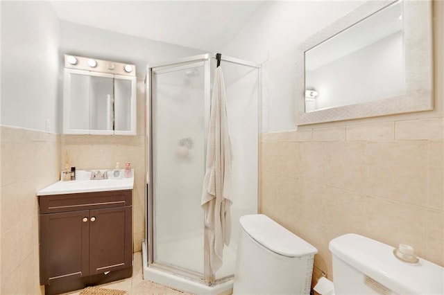 full bath with toilet, a stall shower, tile walls, and vanity